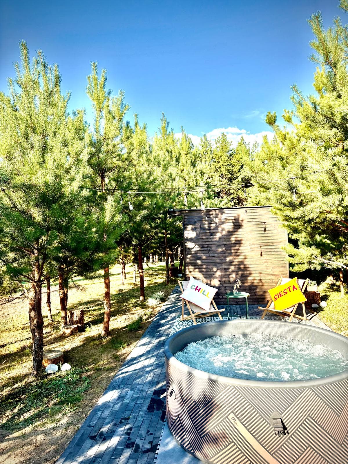Jacuzzi i sauna widziane z leśnej alejki prowadzącej na taras